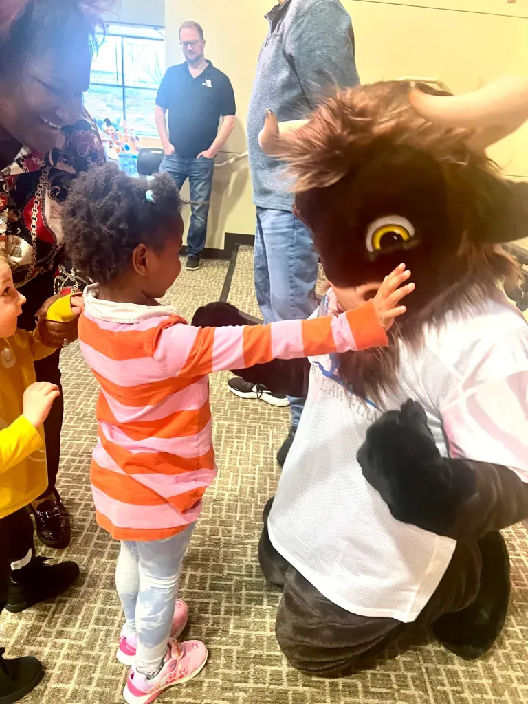 Crash the Bison, Bison Law Firm's mascot, visits the students at Special Care Inc.